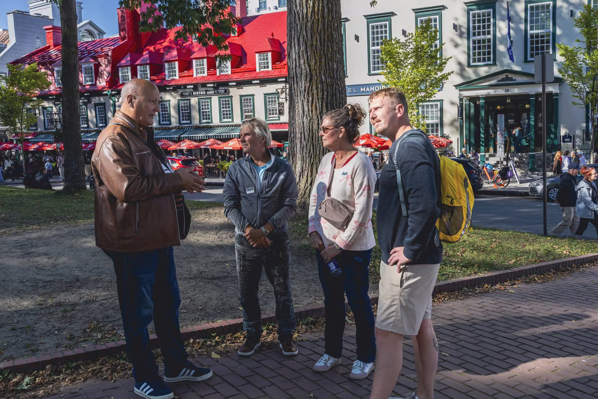 A group gathered with their guide under the trees in Old Québec.