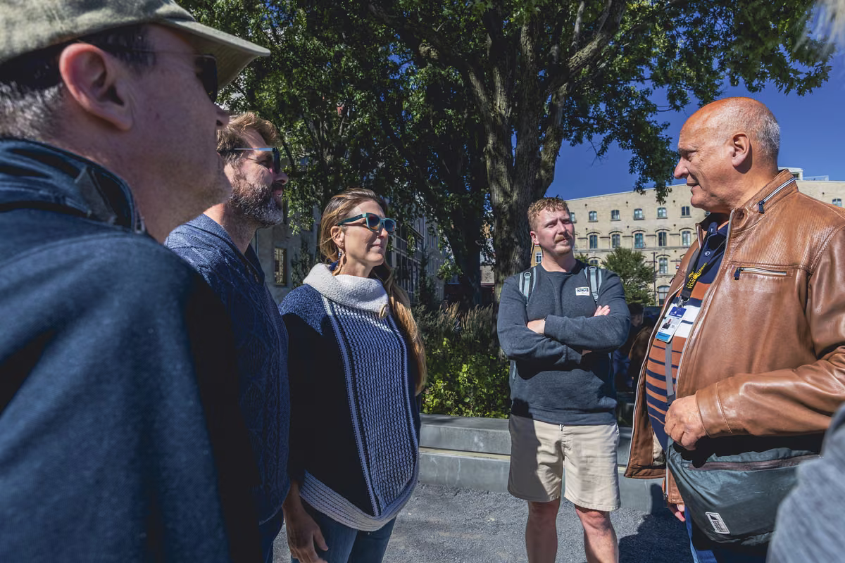 A guide in a leather jacket talking with a group of visitors in Old Québec.