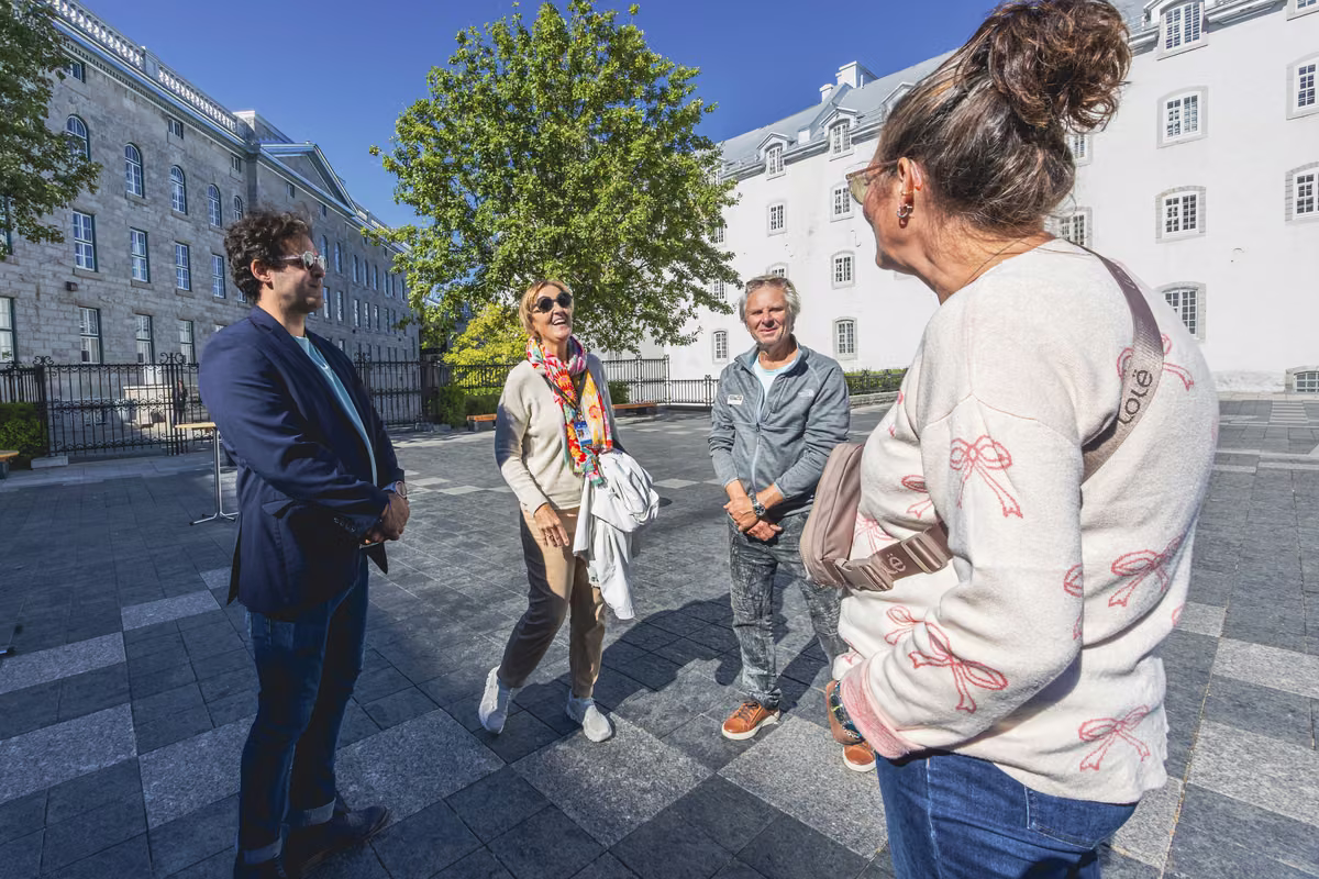 A guide with visitors in a historic square of Old Québec.