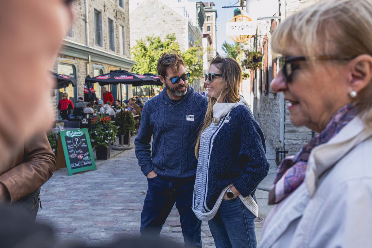 A couple listening to their guide on a street of Old Québec.